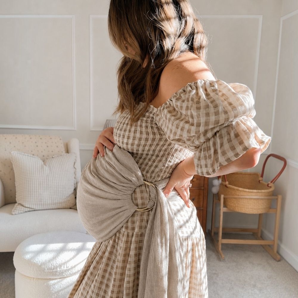 Balküpü Studio %100 keten halka sling kullanan anne. Halka sling kullanmaya başlamadan önce doğru ayarlama, ergonomik taşıma pozisyonu, bebeğin hava yolunun açık olması ve güvenli kullanım kurallarını gösteren bebek taşıma slingi.