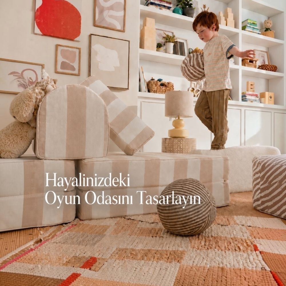 Modüler oyun koltuğuyla hazırlanan ev içi hareket parkurunda oynayan çocuk.