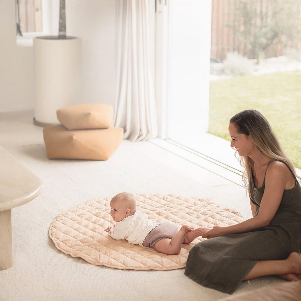 Bebekler için güvenli ve konforlu kapitone oyun halısı üzerinde tummy time etkinliği.