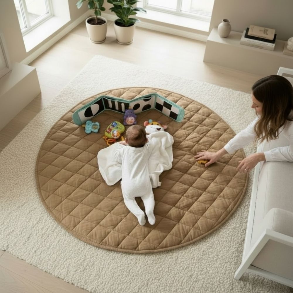 Kapitone oyun halısı üzerinde tummy time yapan bebek ve yanında oyun sürecini destekleyen ebeveyn.